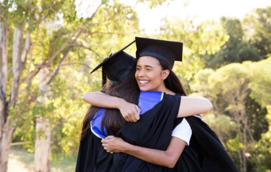 two female chc graduates hugging