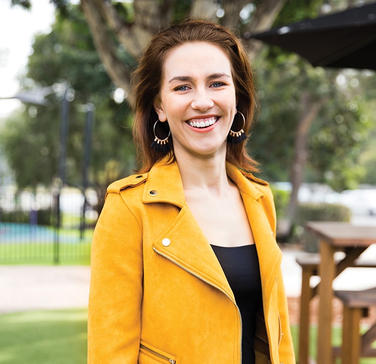 woman in yellow jacket smiling for photo